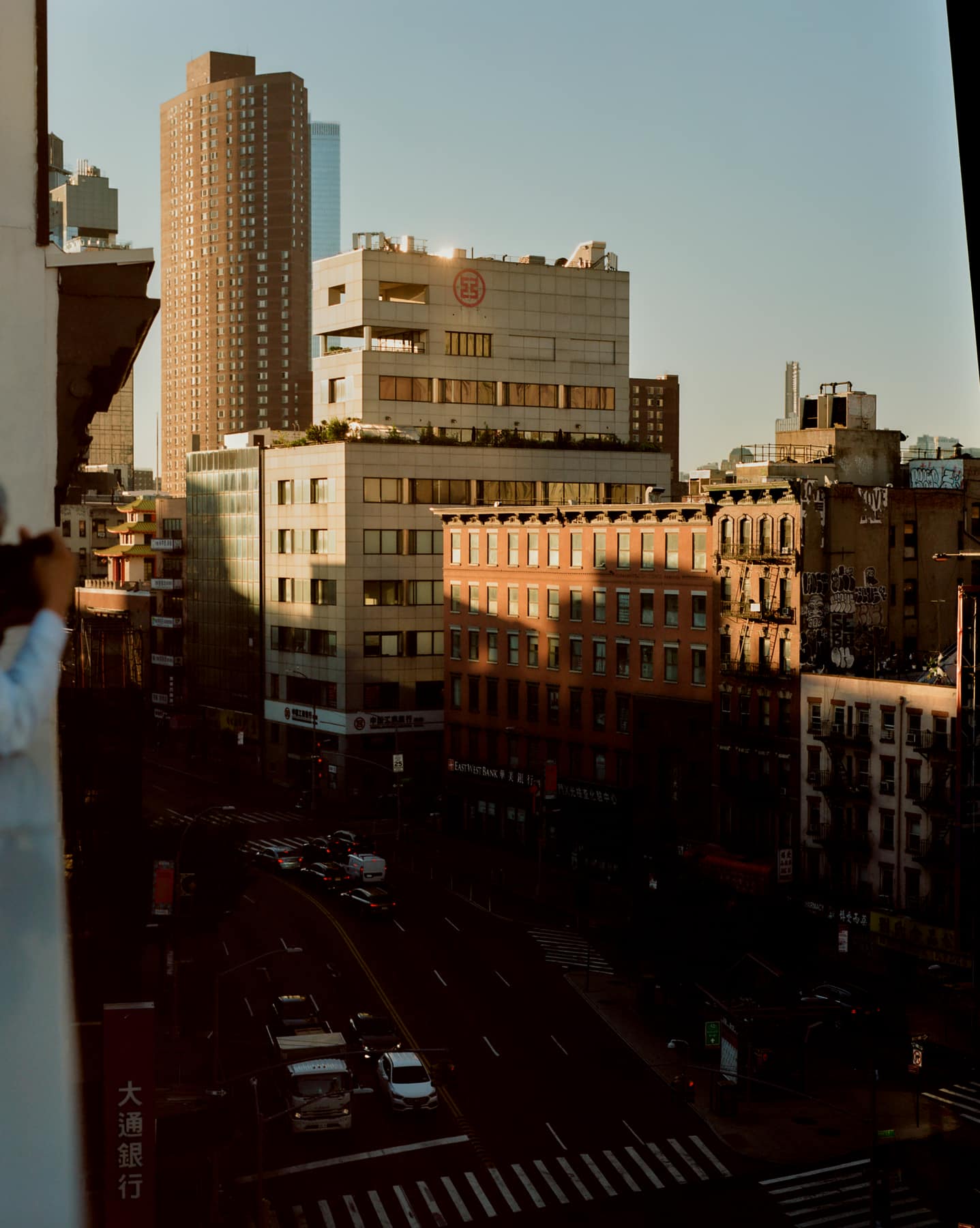 Chinatown rooftops at golden hour, the street and its traffic far below