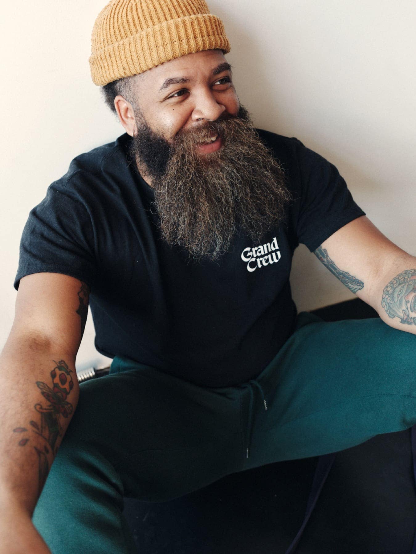 A bearded man in the black Crew tee, laughing