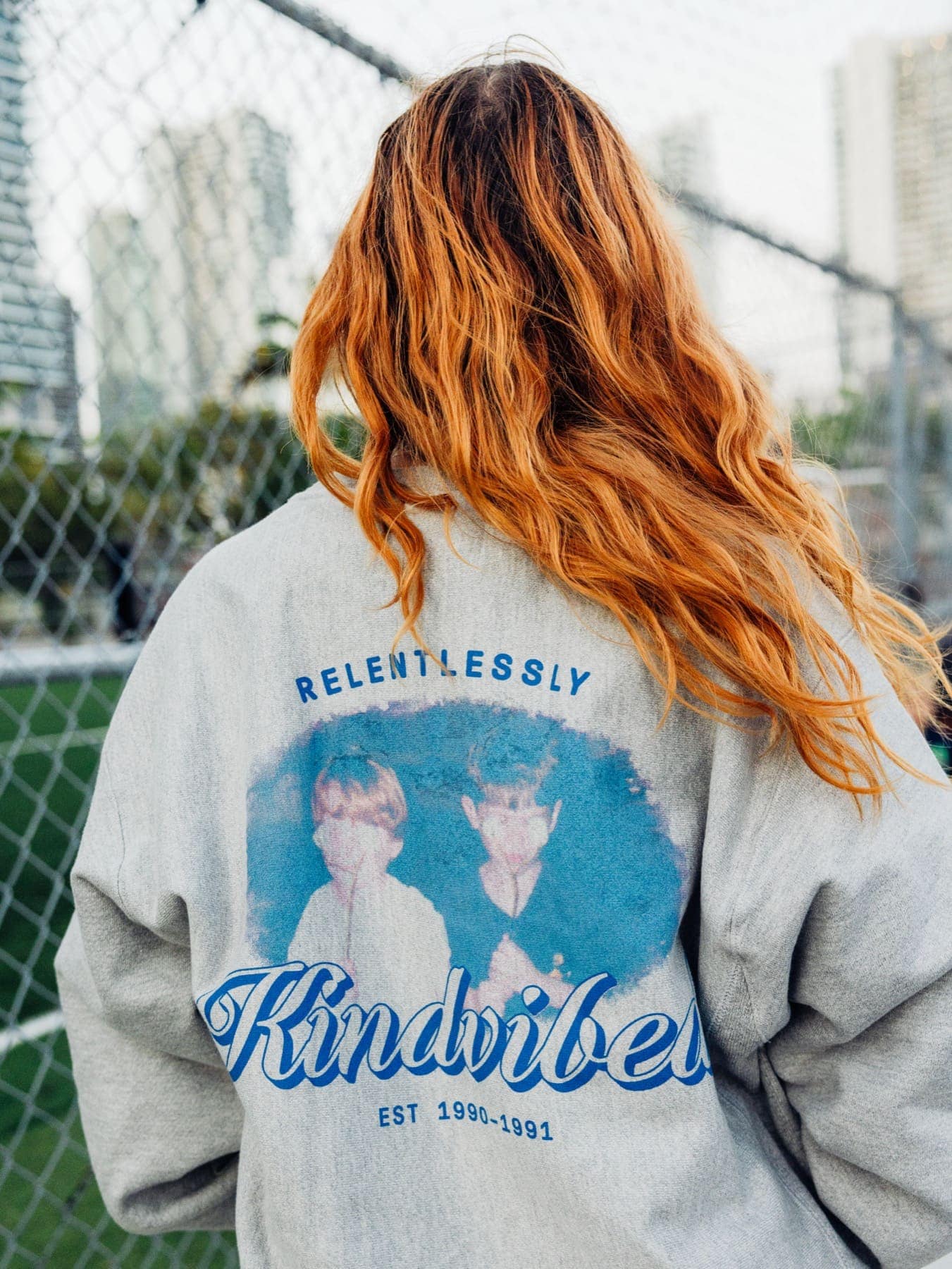 The Kindvibes crewneck from behind on a football field
