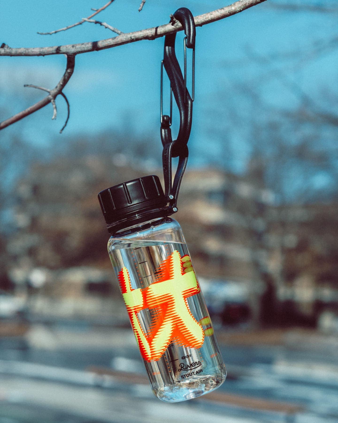 The GCXC bottle hanging from a bare branch