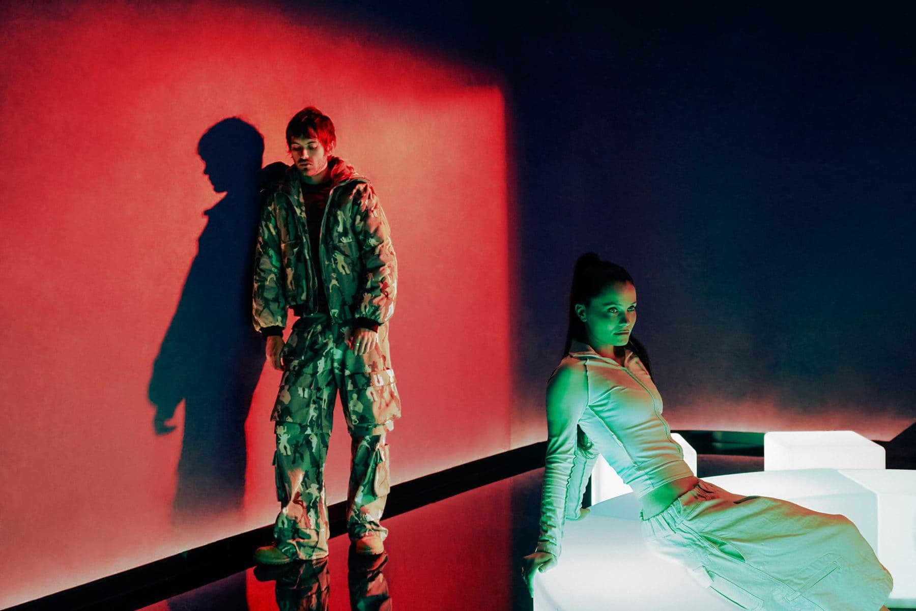 Jackson Walker Lewis against a red wall while Shanny Wise sits on a glowing white bench