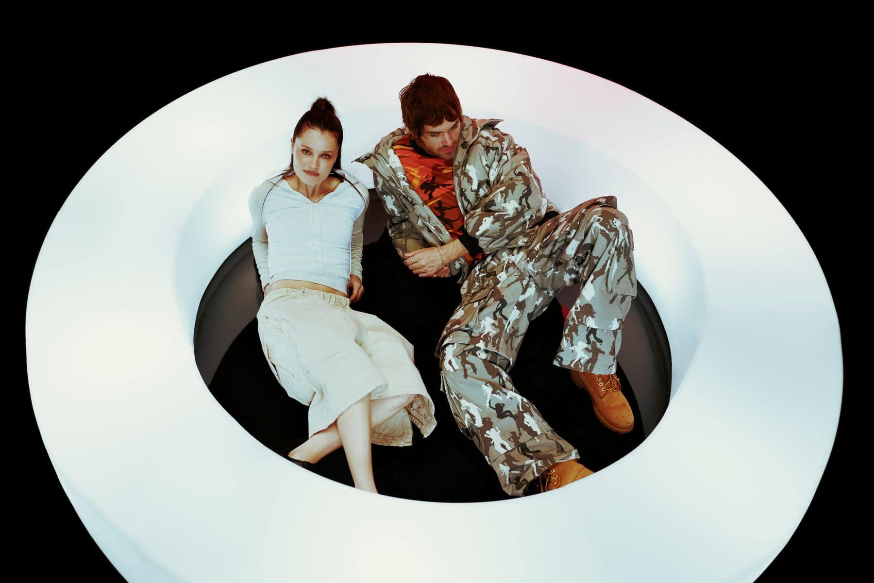 Shanny Wise and Jackson Walker Lewis lying inside the glowing ring bench, seen from above