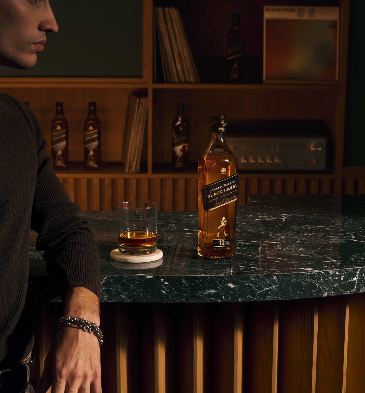A martini and a rocks glass on a leather banquette, lit in warm amber
